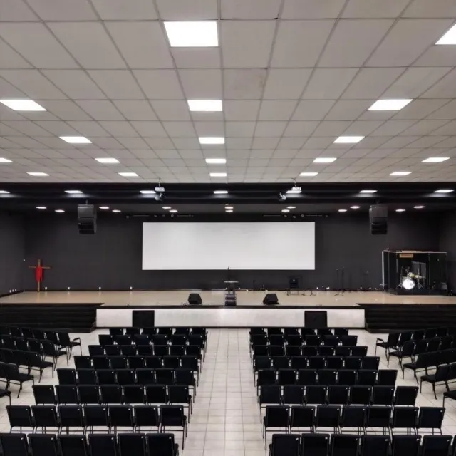 Auditório com cadeiras pretas